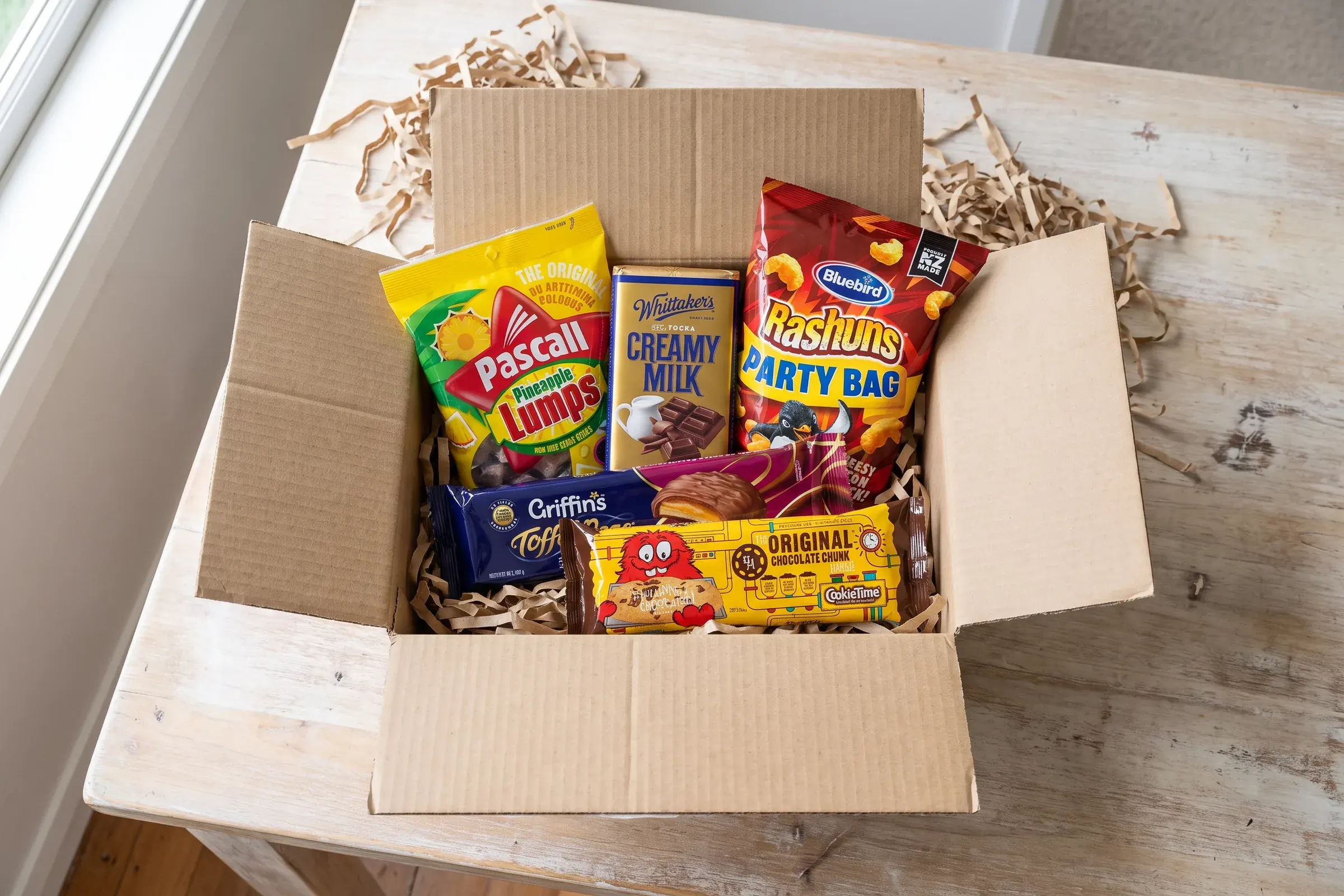 A KiwiKandy box packed with Pineapple Lumps, Whittaker's, Toffee Pops and Rashuns