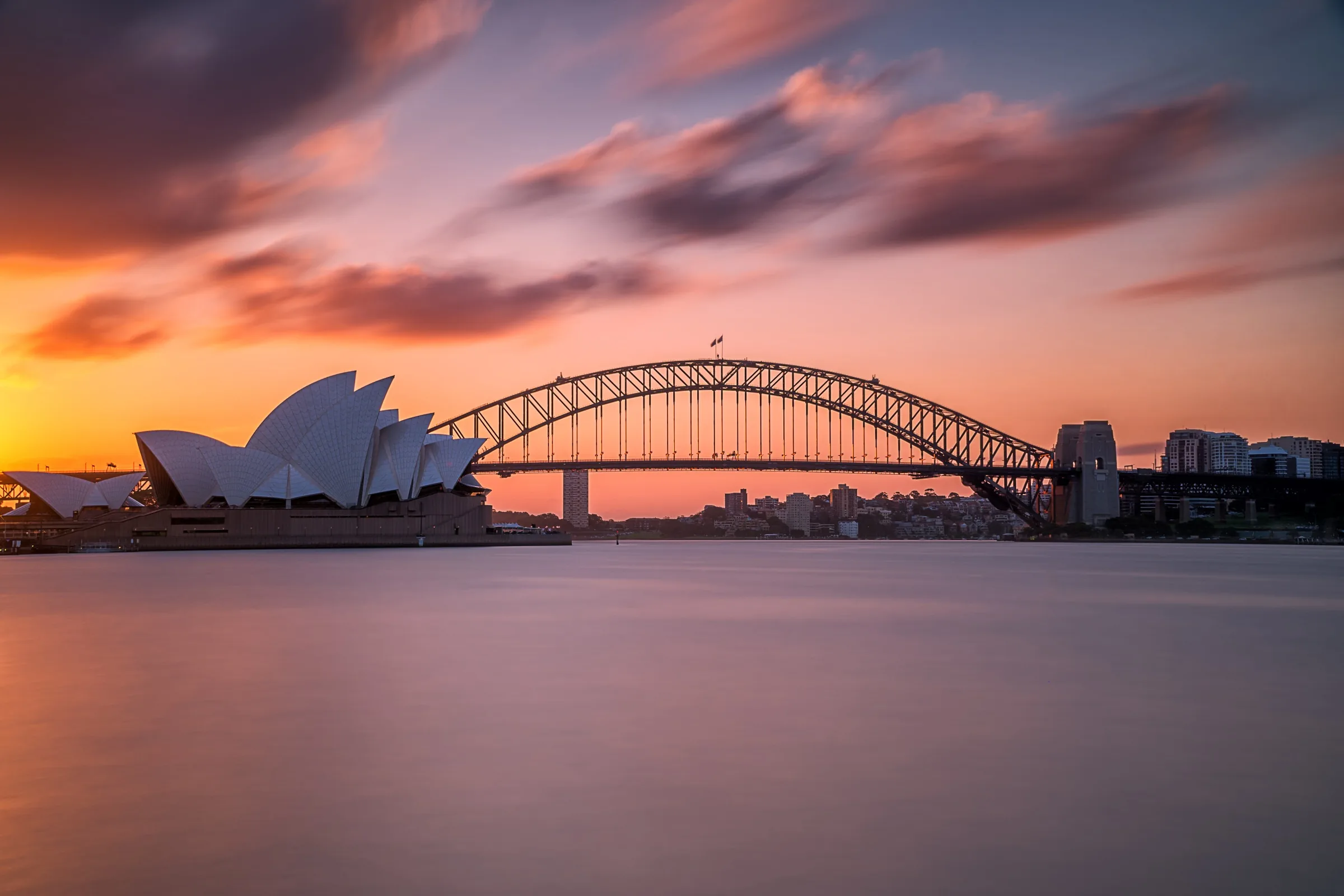 Sydney Harbour at sunset, the bridge and the Opera House in silhouette